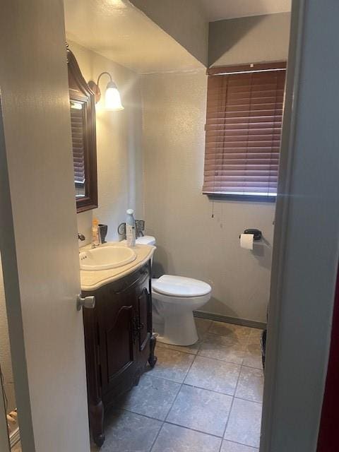 bathroom featuring tile patterned flooring, vanity, and toilet