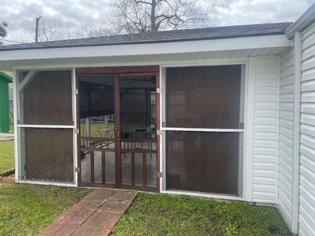 doorway to property featuring roof with shingles