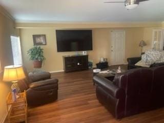 living area featuring ornamental molding, ceiling fan, baseboards, and wood finished floors