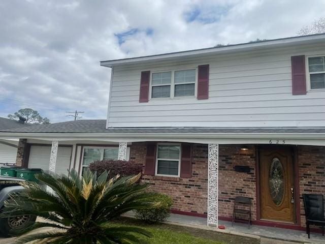 view of front facade featuring brick siding and an attached garage