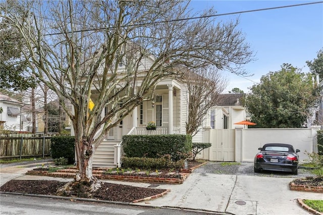 view of front of property with a porch, fence, and a gate