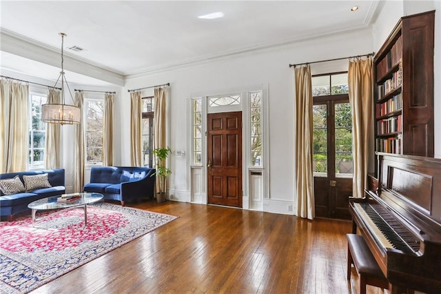 foyer entrance with crown molding, visible vents, plenty of natural light, and hardwood / wood-style flooring