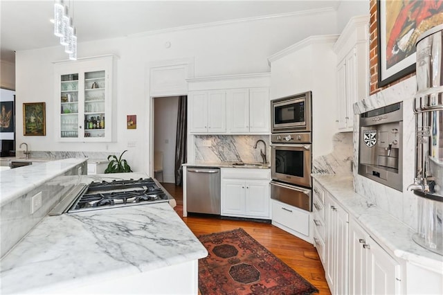 kitchen featuring dark wood-style floors, a warming drawer, stainless steel appliances, white cabinetry, and a sink