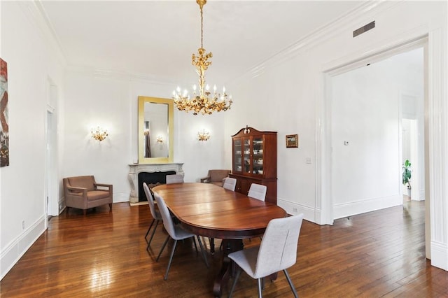 dining room featuring visible vents, ornamental molding, a fireplace, and hardwood / wood-style floors