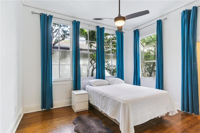 bedroom featuring ceiling fan, wood finished floors, and baseboards