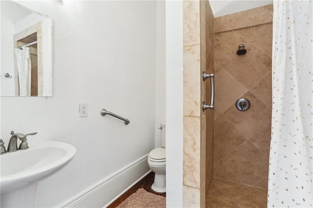 full bathroom featuring toilet, a sink, and tiled shower