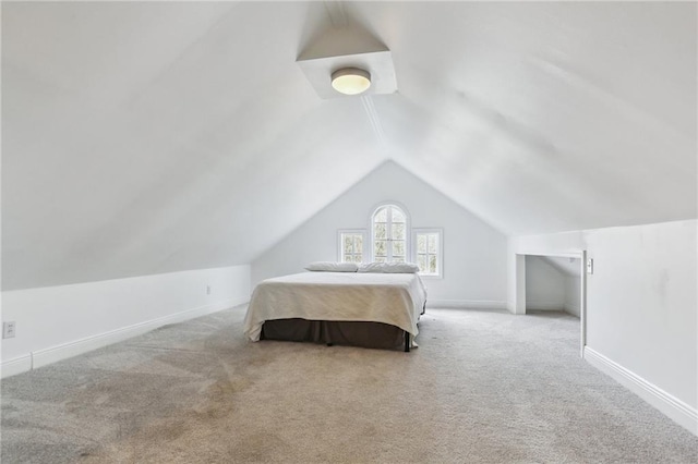 bedroom with carpet floors, lofted ceiling, and baseboards