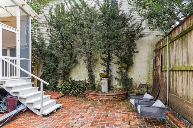 view of patio / terrace featuring a sunroom and fence