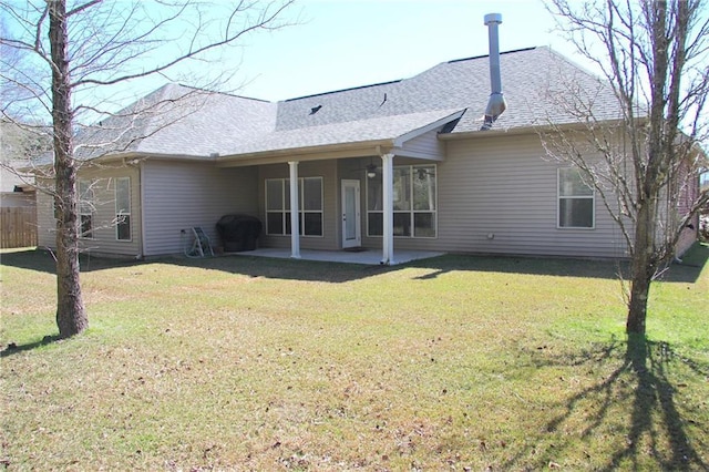 back of property with a patio area, a shingled roof, fence, and a yard