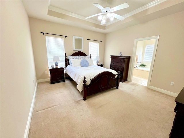 bedroom with ornamental molding, a tray ceiling, light carpet, and baseboards