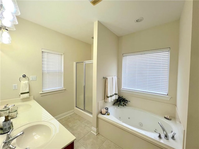 bathroom with a shower stall, double vanity, a sink, and tile patterned floors