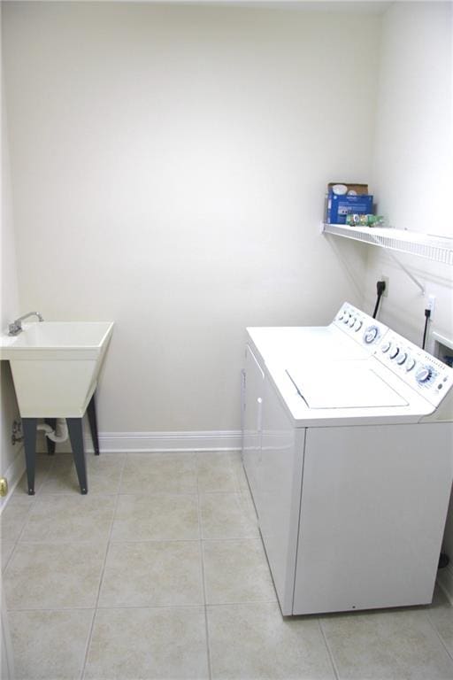 washroom featuring laundry area, light tile patterned flooring, baseboards, and independent washer and dryer