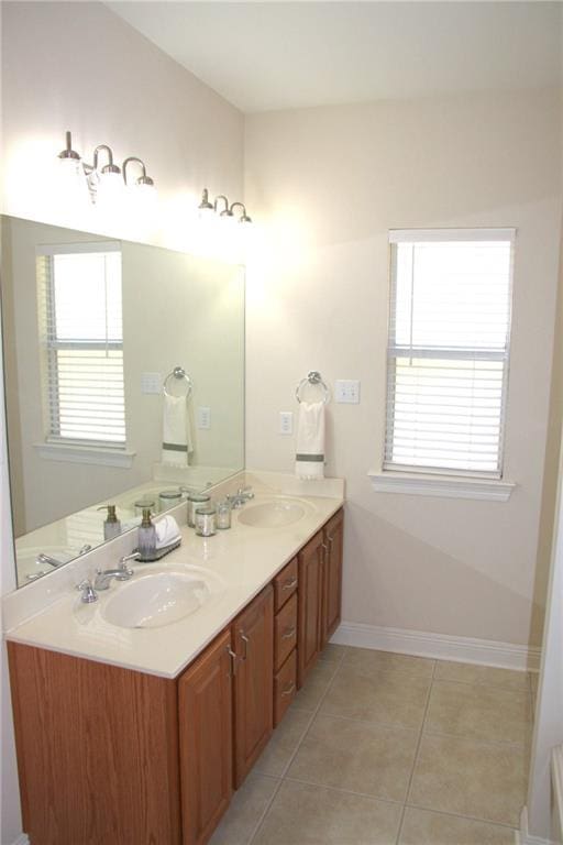 full bath with a healthy amount of sunlight, tile patterned flooring, and a sink