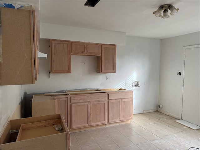 kitchen with ventilation hood, light tile patterned flooring, and baseboards