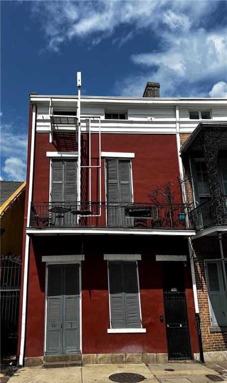 exterior space with a chimney and a balcony