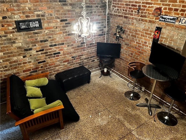 living area with brick wall, granite finish floor, and baseboards