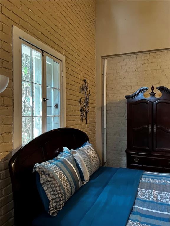 bedroom featuring brick wall