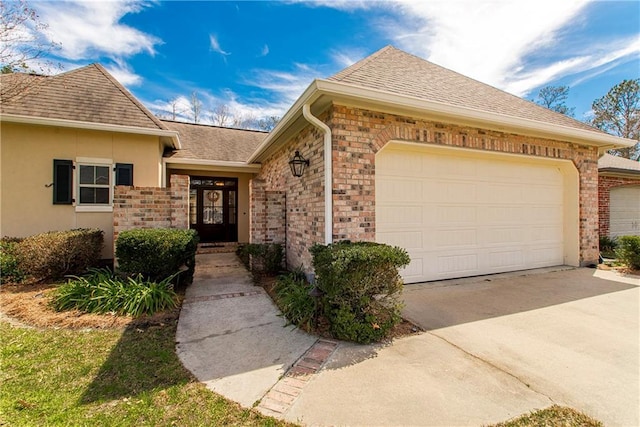 view of front of home with a garage, concrete driveway, roof with shingles, and stucco siding