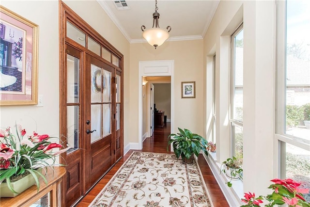 entryway featuring ornamental molding, dark wood-type flooring, plenty of natural light, and visible vents