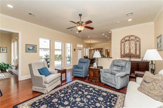 living room featuring dark wood-style floors, baseboards, visible vents, and ornamental molding