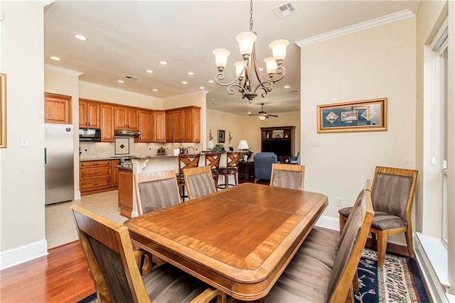 dining area featuring ornamental molding, visible vents, baseboards, and ceiling fan with notable chandelier