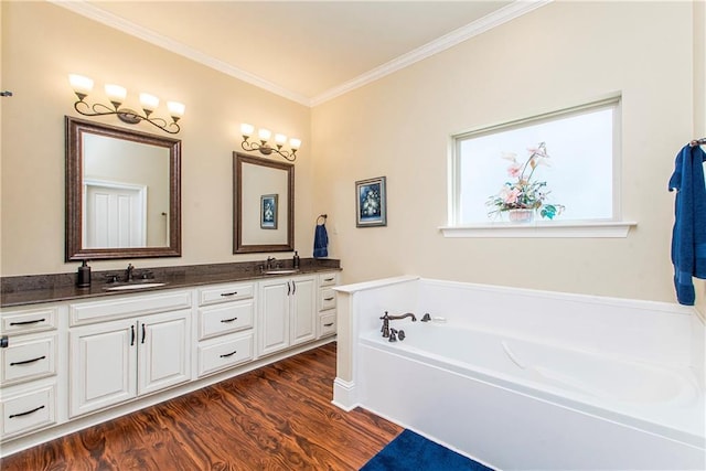 bathroom featuring a garden tub, double vanity, ornamental molding, a sink, and wood finished floors