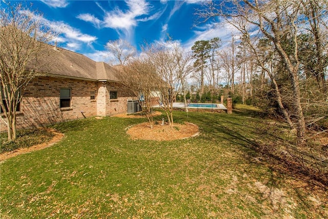 view of yard with an outdoor pool and central AC unit