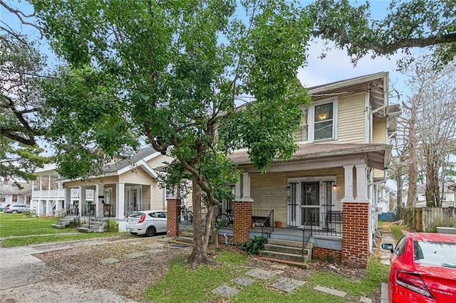 american foursquare style home featuring a porch