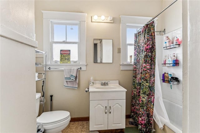 full bathroom with toilet, vanity, a wealth of natural light, and baseboards