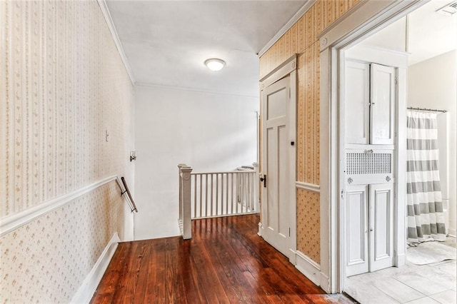 hall featuring visible vents, ornamental molding, an upstairs landing, hardwood / wood-style floors, and wallpapered walls