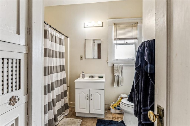 bathroom with curtained shower, vanity, and toilet