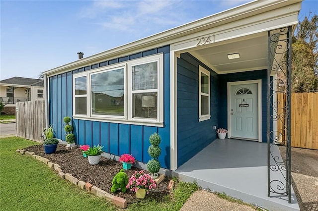 property entrance with fence and board and batten siding