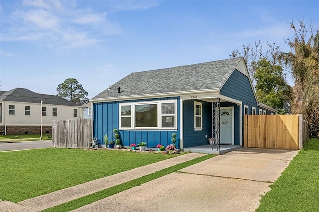 bungalow-style house featuring a porch, fence, roof with shingles, a front lawn, and board and batten siding