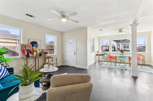 foyer entrance featuring ornate columns, visible vents, a ceiling fan, wood finished floors, and baseboards