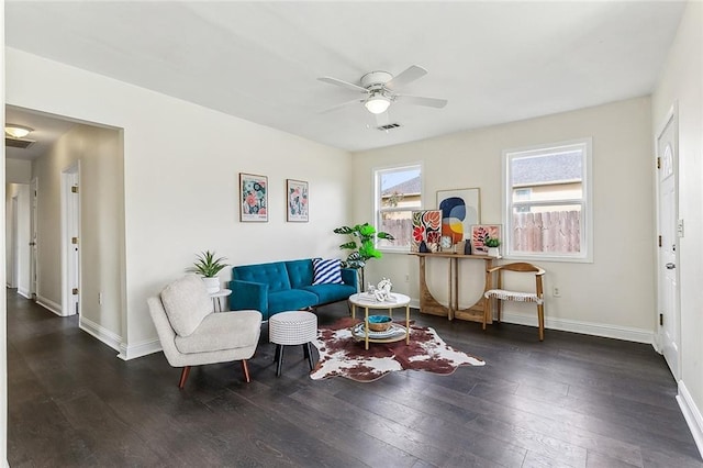 living room with ceiling fan, visible vents, hardwood / wood-style flooring, and baseboards