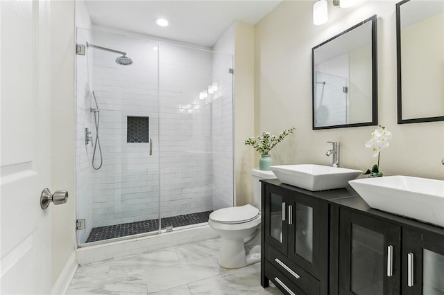 bathroom with toilet, marble finish floor, a shower stall, and a sink