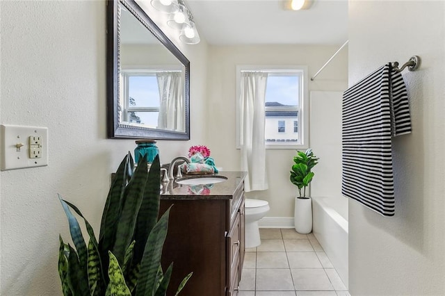 bathroom with tile patterned flooring, toilet, vanity, baseboards, and shower / bath combo