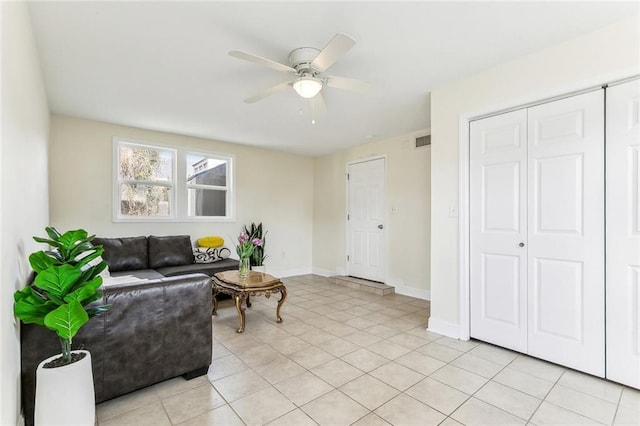 living area with light tile patterned floors, ceiling fan, visible vents, and baseboards