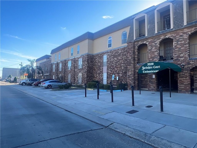 view of building exterior with uncovered parking