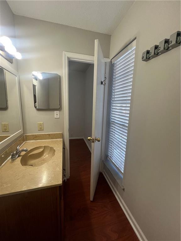 bathroom with vanity, baseboards, and wood finished floors