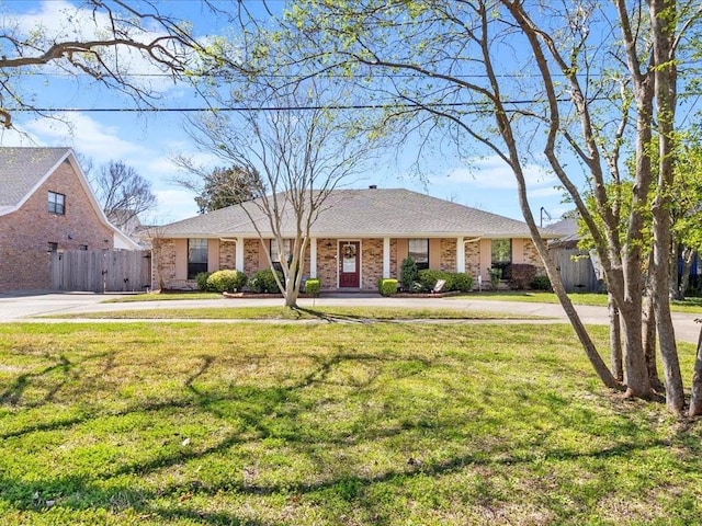 single story home featuring a front yard, brick siding, and fence