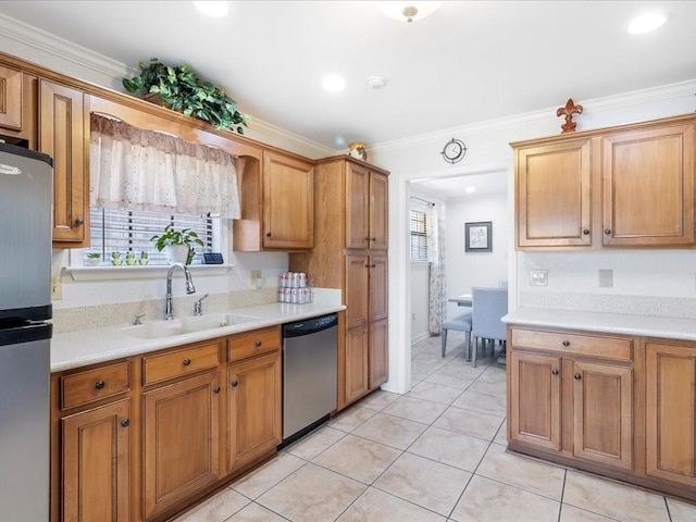 kitchen featuring appliances with stainless steel finishes, light countertops, a sink, and ornamental molding