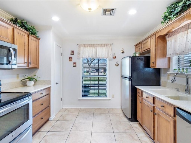 kitchen featuring stainless steel appliances, light countertops, a sink, and visible vents