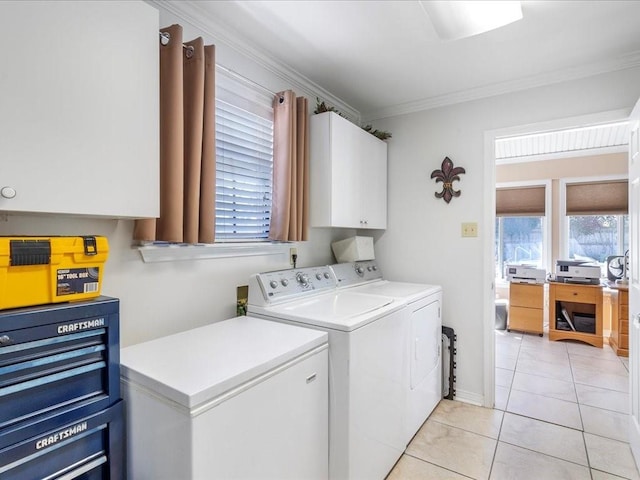 clothes washing area featuring light tile patterned floors, washer and clothes dryer, cabinet space, and crown molding