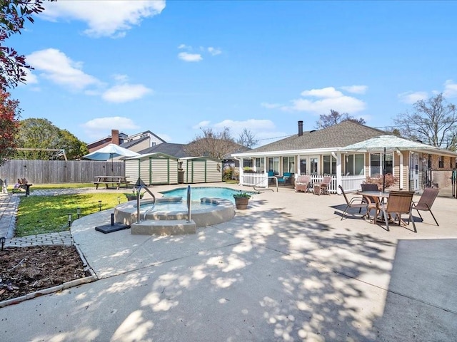 view of swimming pool with an outbuilding, a patio, a lawn, a shed, and a fenced backyard