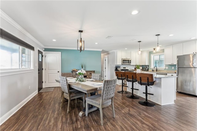 dining area with ornamental molding, recessed lighting, and dark wood-style flooring