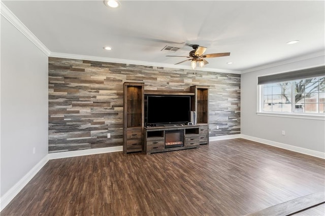 unfurnished living room with baseboards, an accent wall, wood finished floors, crown molding, and recessed lighting