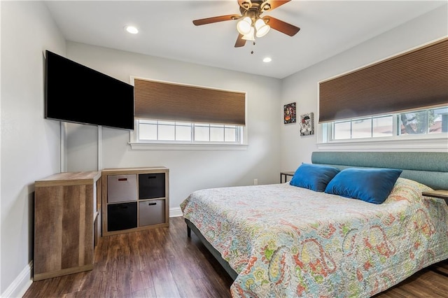 bedroom with multiple windows, baseboards, and wood finished floors