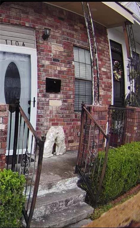 doorway to property featuring brick siding