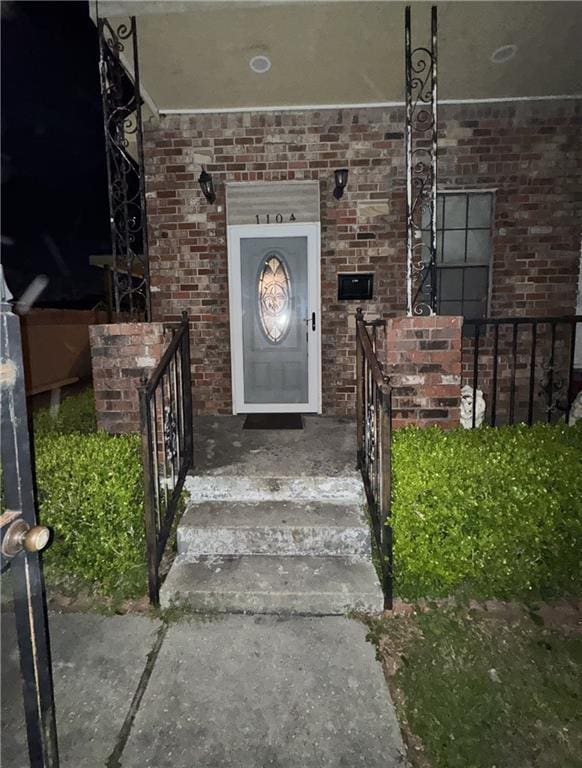 doorway to property featuring brick siding